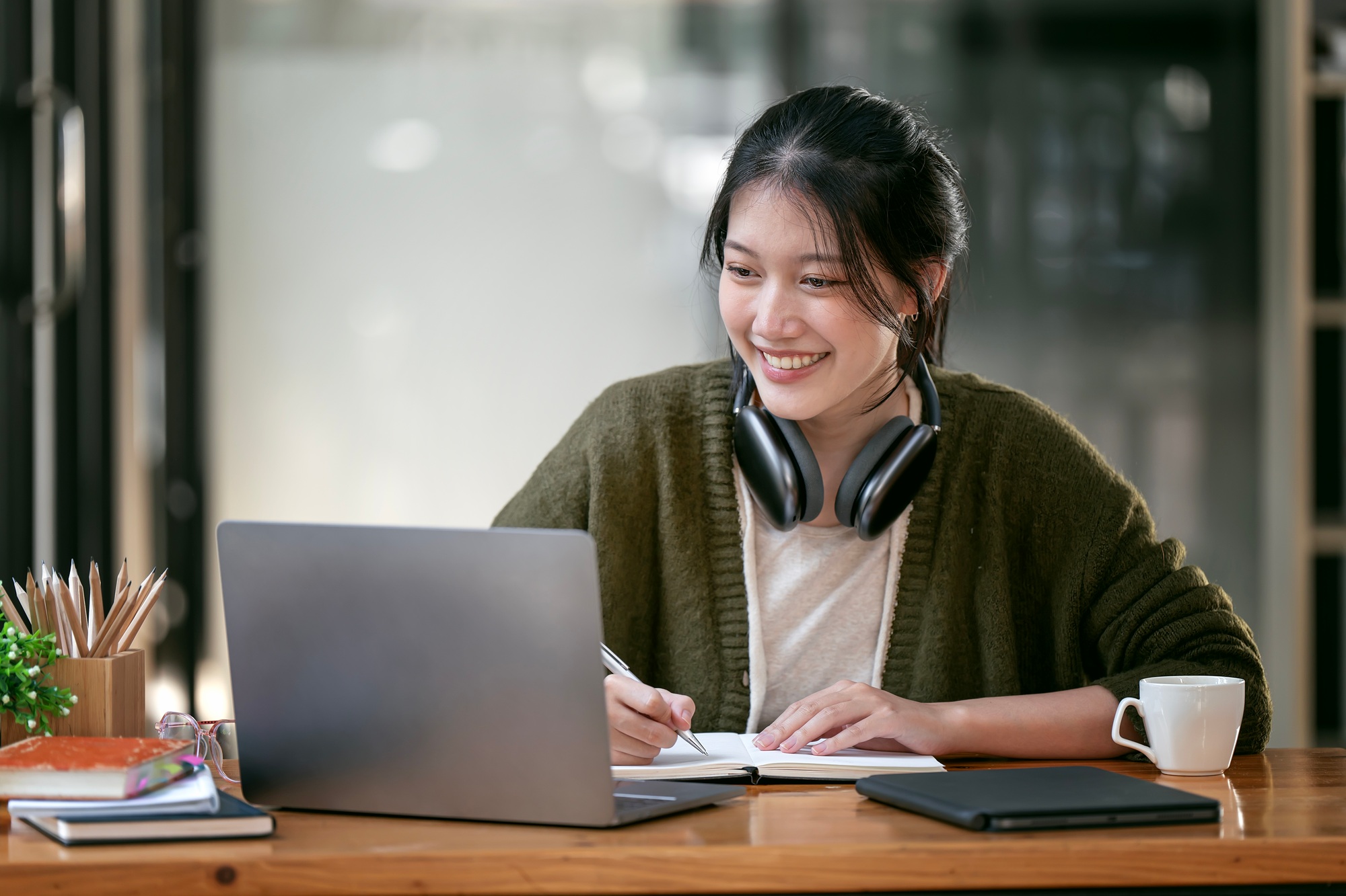Portrait confident young female college student studying online via laptop computer