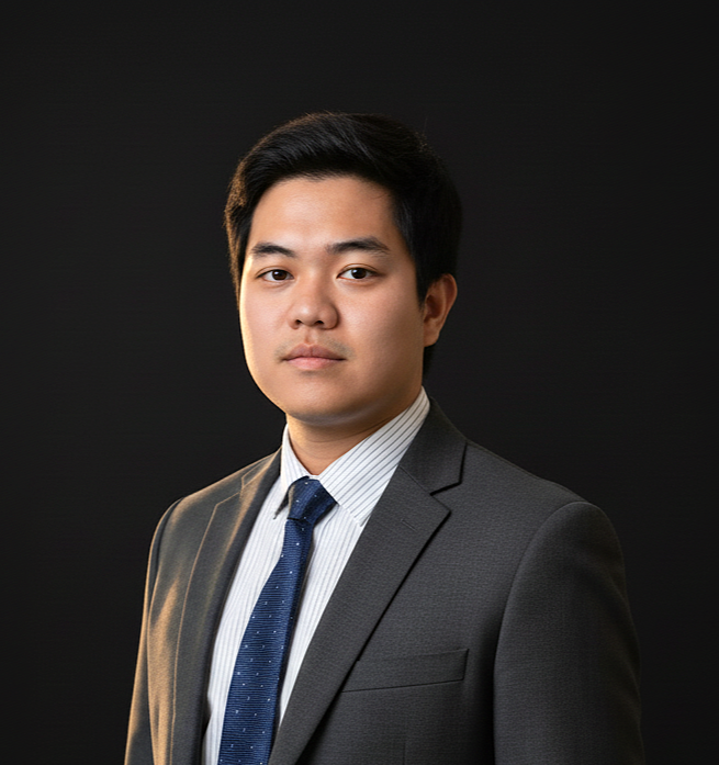 About Us 11 Juan Carlos Marco wearing formal business attire, standing confidently against a black background with hands in pockets and a neutral expression.